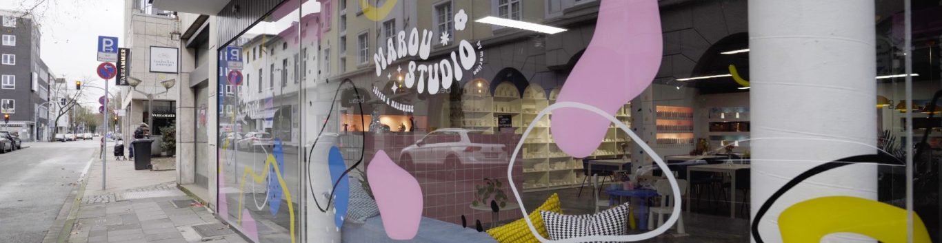 Schaufenster mit bunten Mustern und einem Blick auf die Straße.